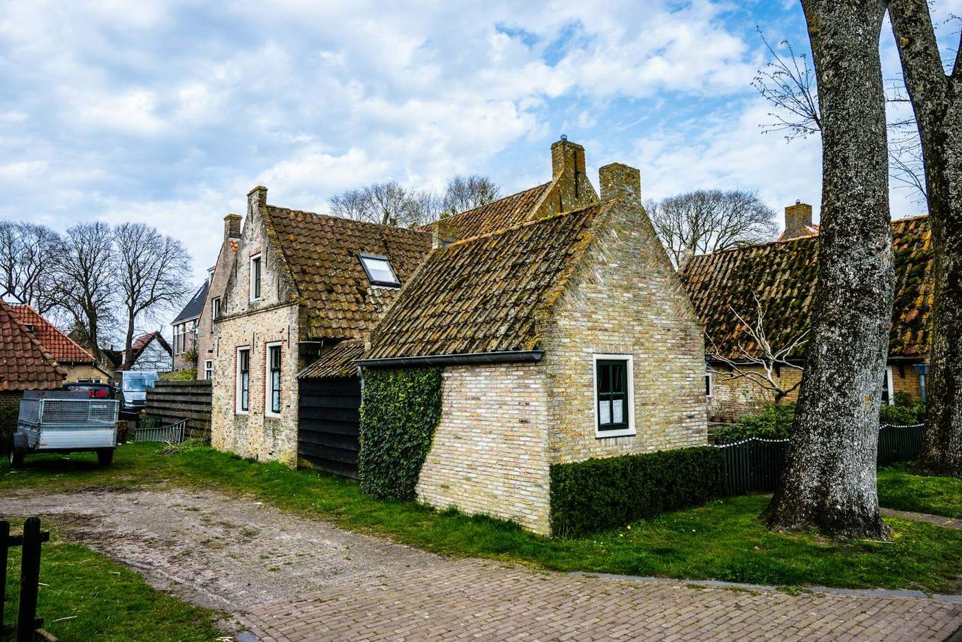 Oude stenen woningen met pannendaken langs een landweg